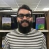 This is an image of Tegid, smiling in front of a book case.